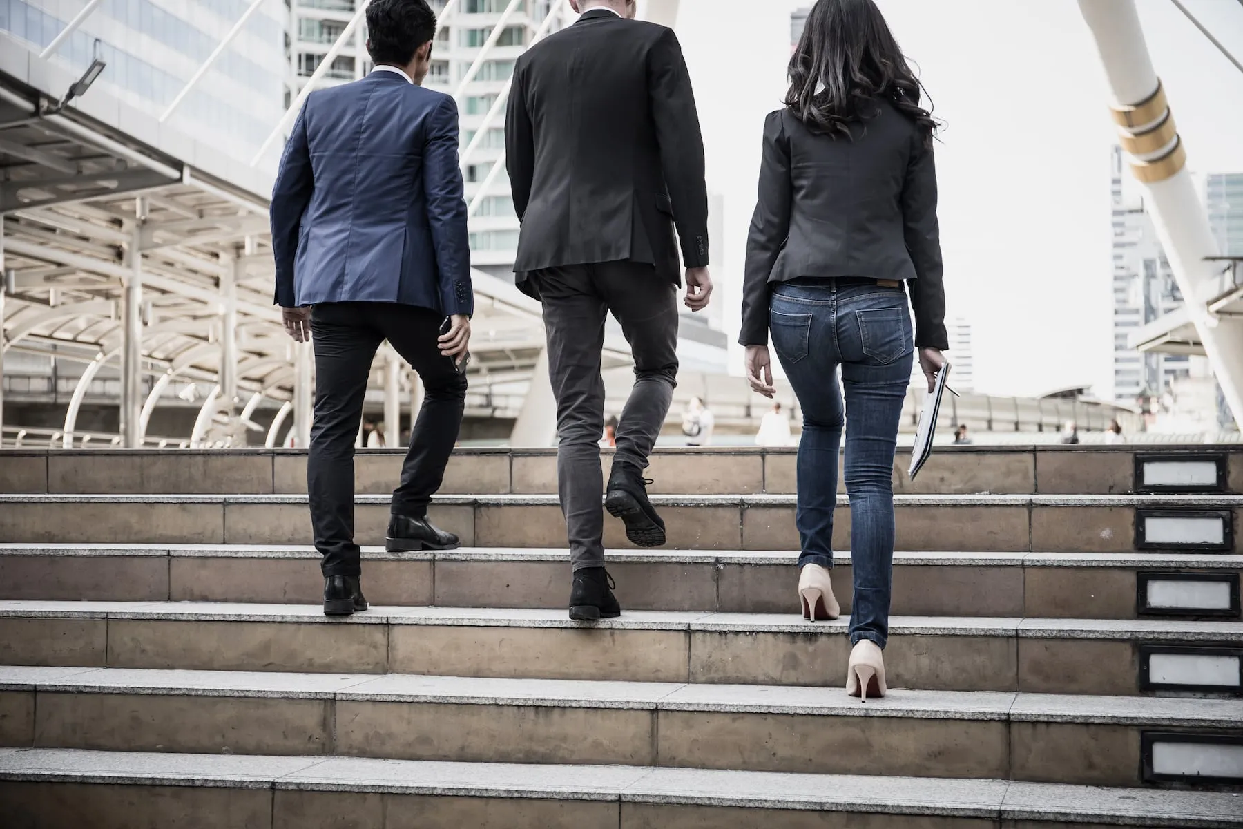 Three leaders walking up steps together